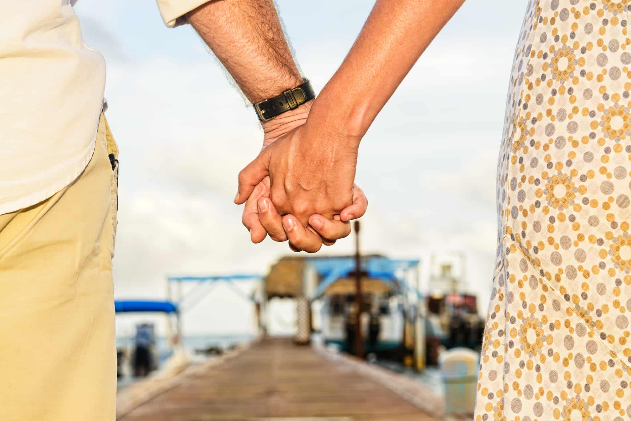 Close-up of couple holding hands from behind